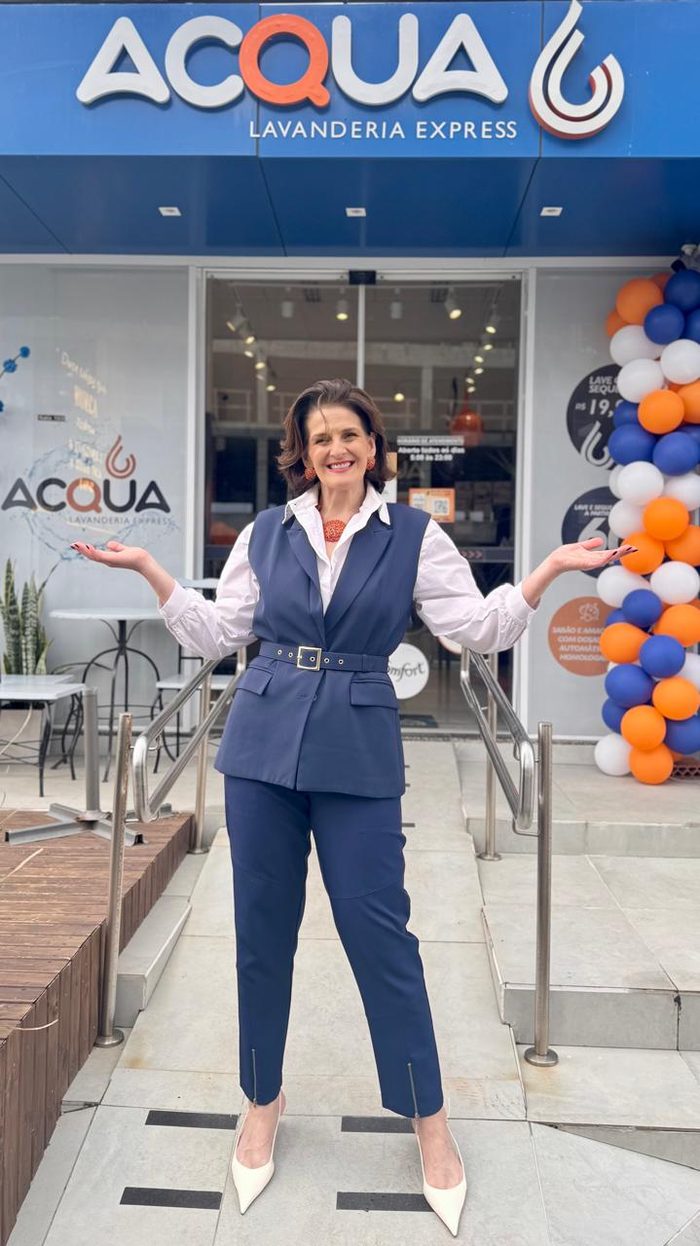 Dona da Acqua Lavanderia Express na porta da loja